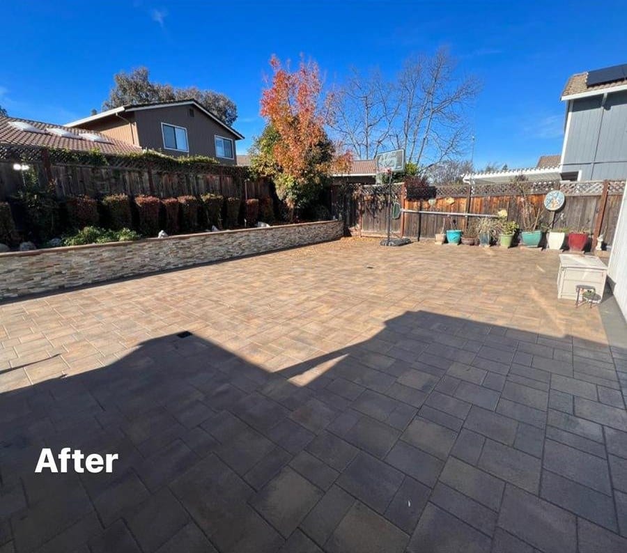 The same backyard after pool demolition and backfill, finished as a large paver patio