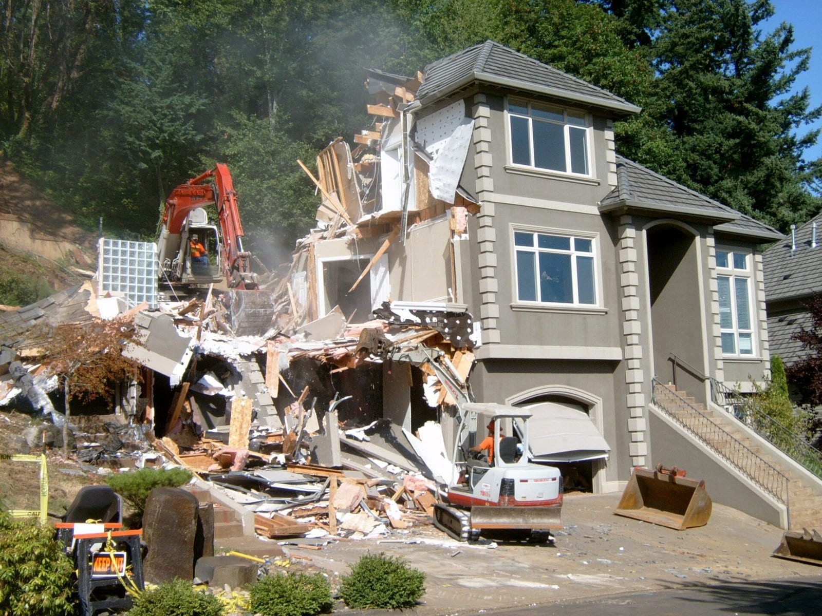 Excavator and skid steer demolishing a house on a Royal Demolition job site in the Bay Area